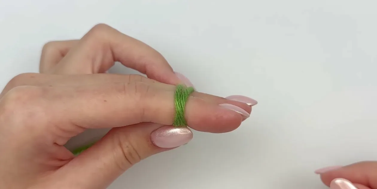 Yarn wrapped around two fingers to begin the magic circle