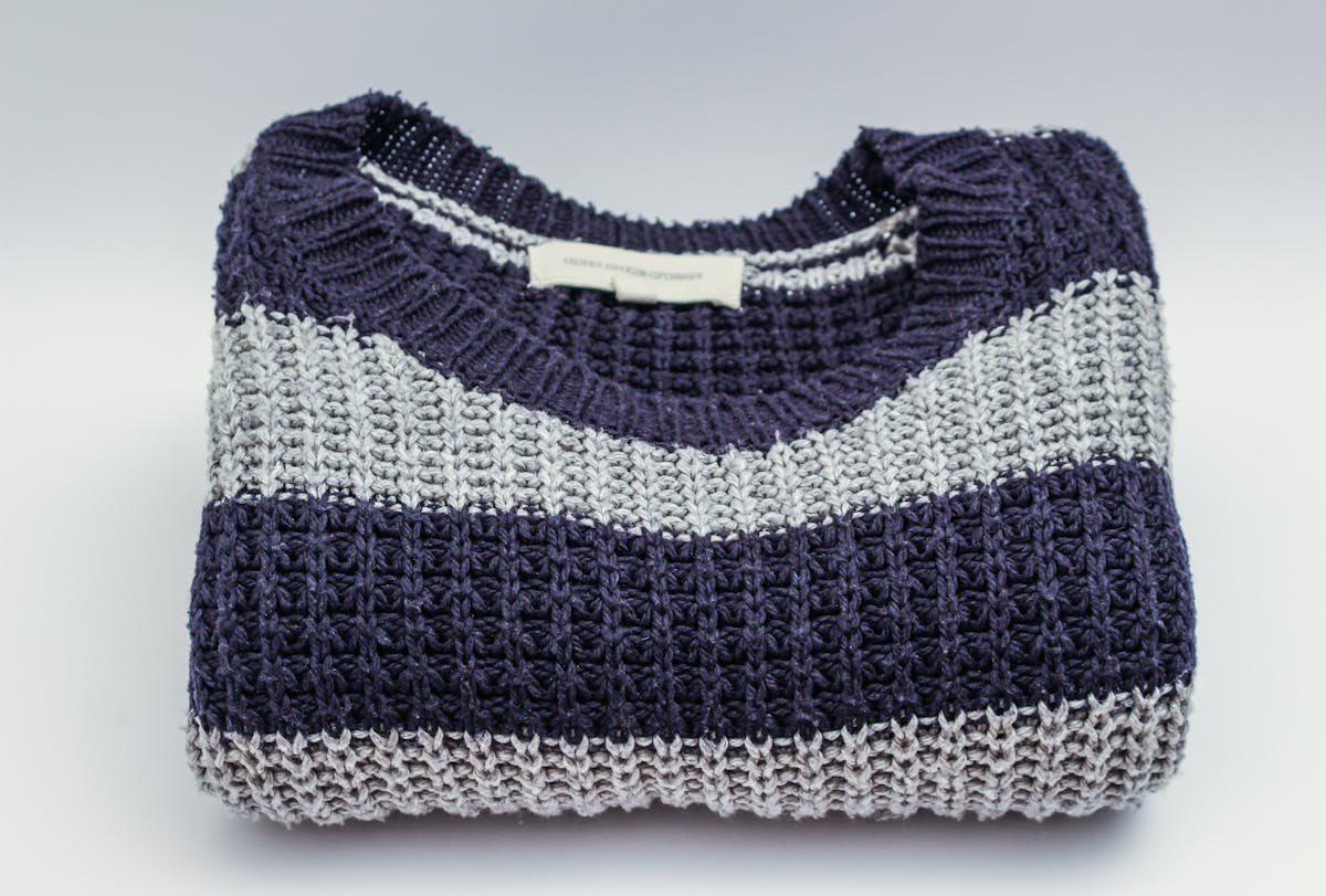 Knit sweater flat lay showing raglan sleeve construction technique