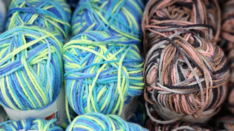 Colorful yarn balls arranged for a crochet bucket hat project showing soft DK weight wool in blue green and brown hues perfect for granny stitch colorwork