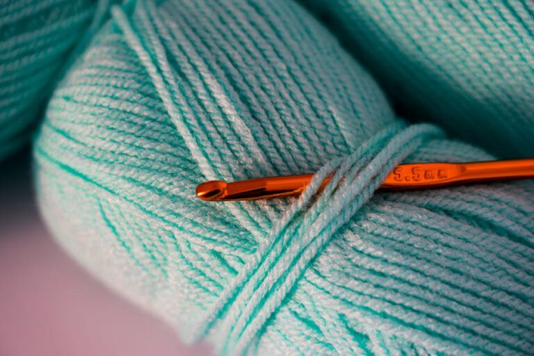 Crochet gauge swatch with teal yarn and crochet hook showing tension and stitch size