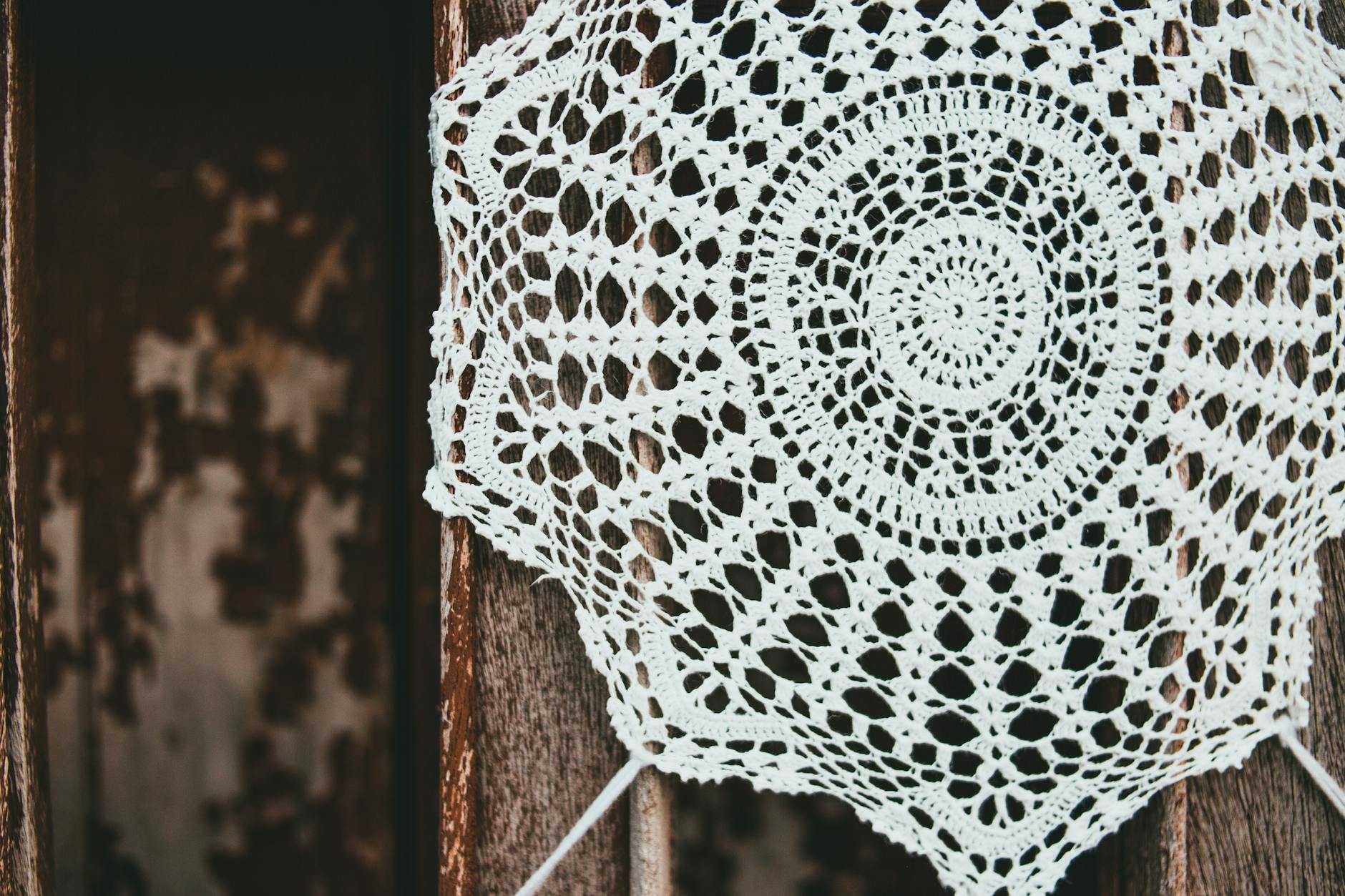 Delicate crochet doily napkin with intricate lace design on wood