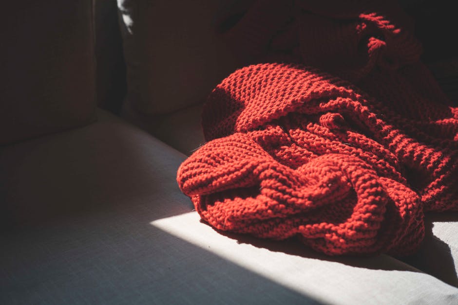 Cozy red knitted blanket in warm sunlight for granny stripe blanket inspiration