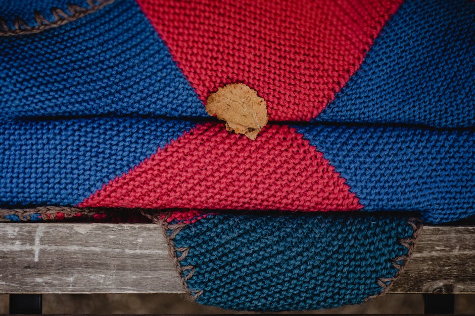 Handmade colorful crochet blanket draped on a wooden bench