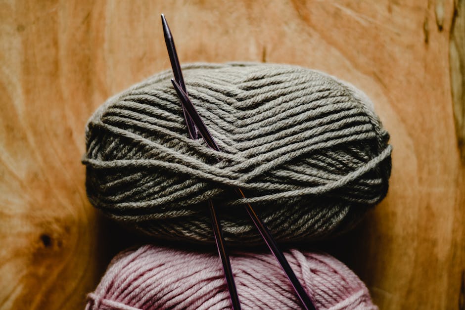 how to stop crochet from twisting beginner — yarn balls and needles on wooden surface