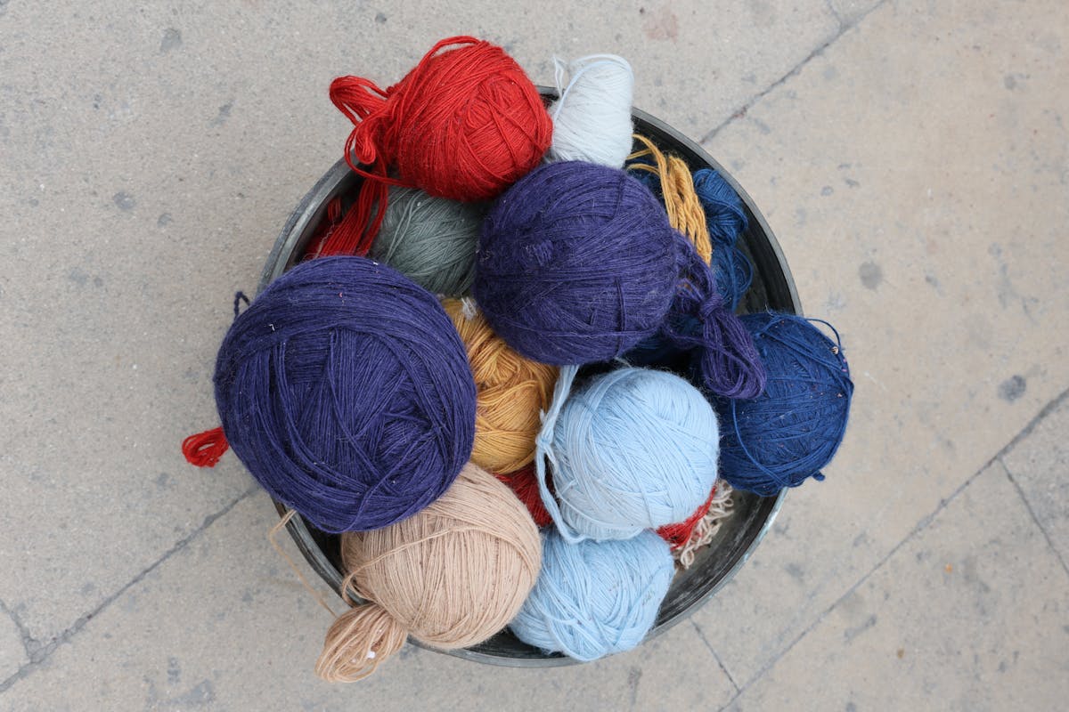 Finger crochet bag pattern – colorful chunky yarn balls in a metal bowl