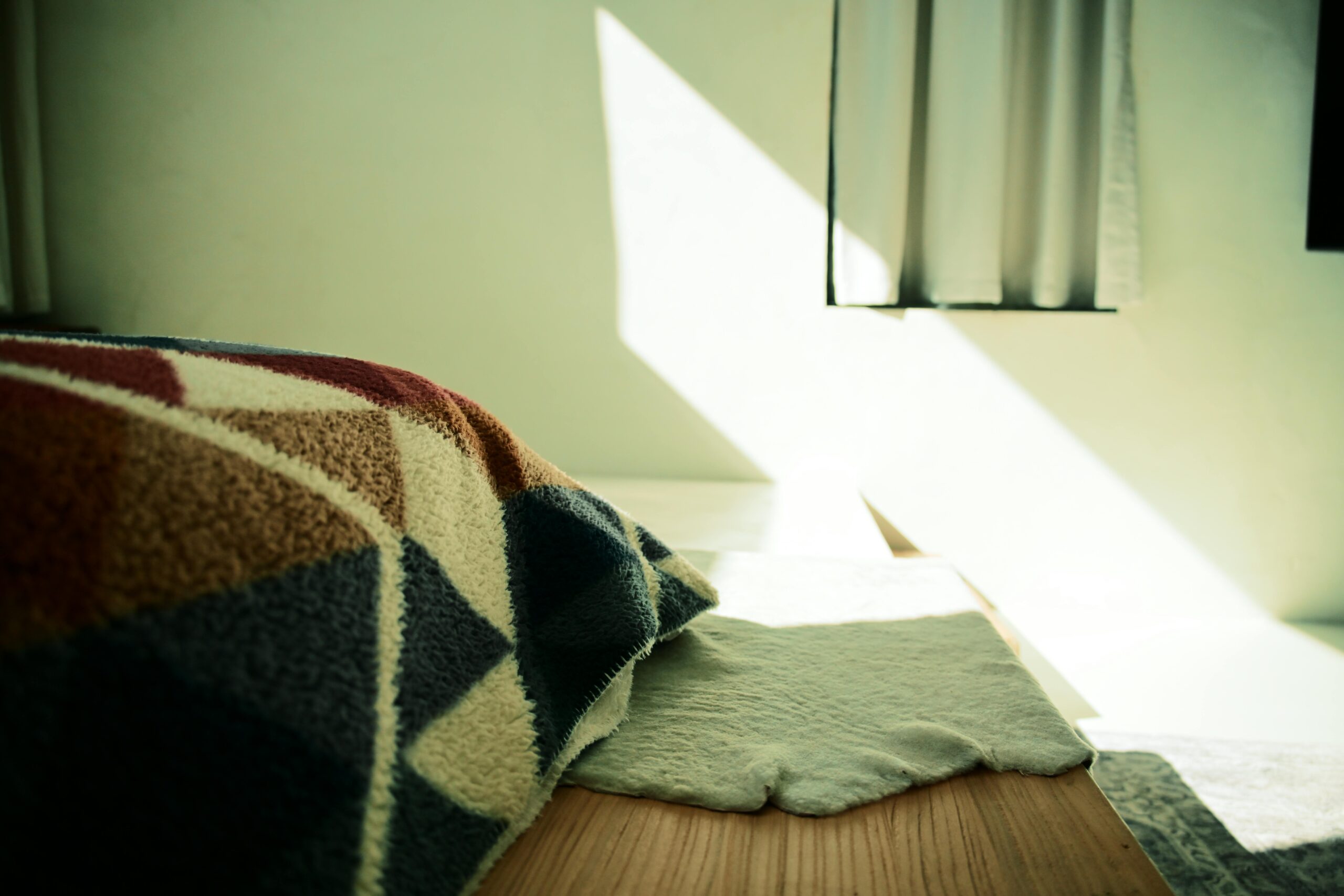 Cozy sunlit bedroom with colorful handmade blanket and crochet lounge pants pattern aesthetic