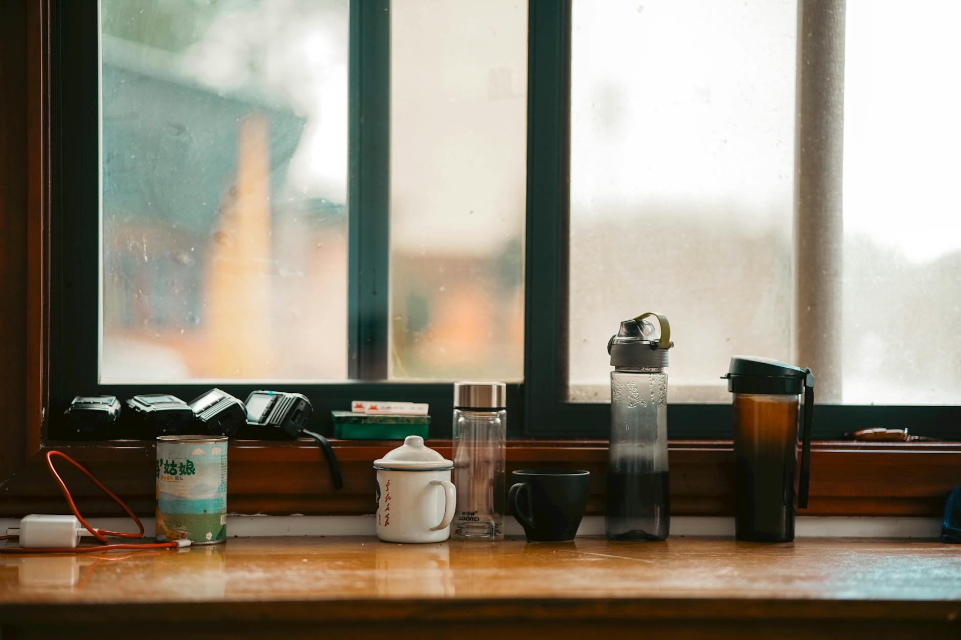 crochet water bottle holder - Various mugs and bottles on a window sill, showcasing an everyday indoor scene.