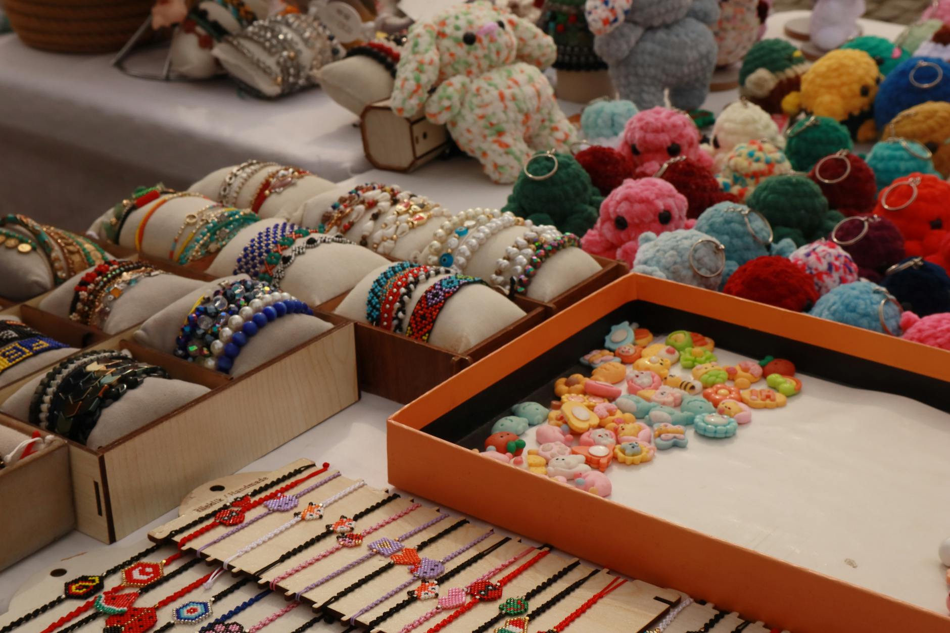 crochet keychain patterns - Vibrant display of handmade bracelets and crocheted keychains at a market stall.