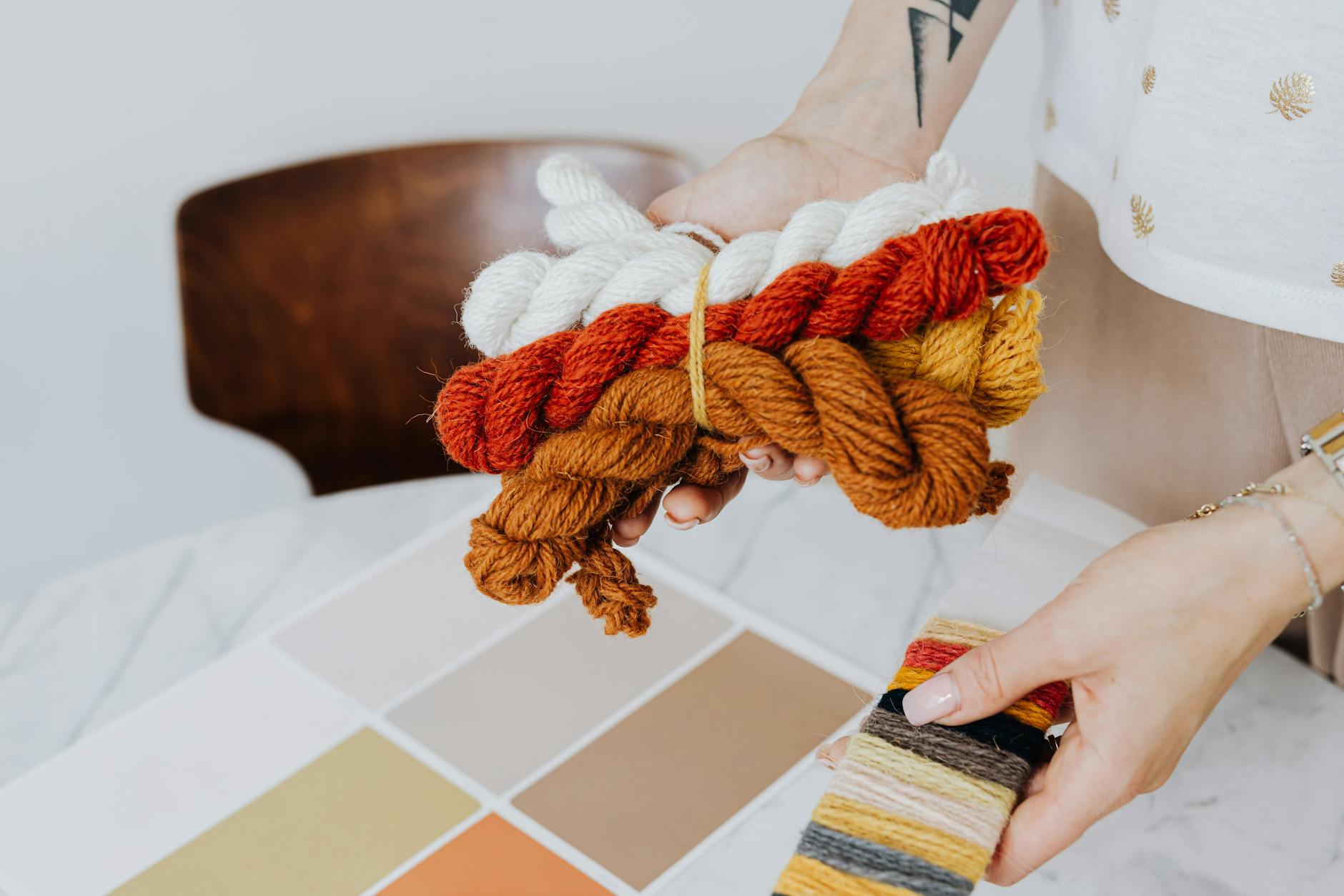 crochet gauge tips for beginners - Hands holding colorful yarn and fabric swatches for creative design and craft projects.