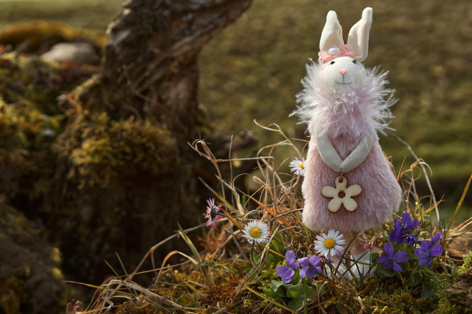 crochet bunny patterns guide - Adorable plush rabbit toy in a garden surrounded by vibrant daisies and violets.