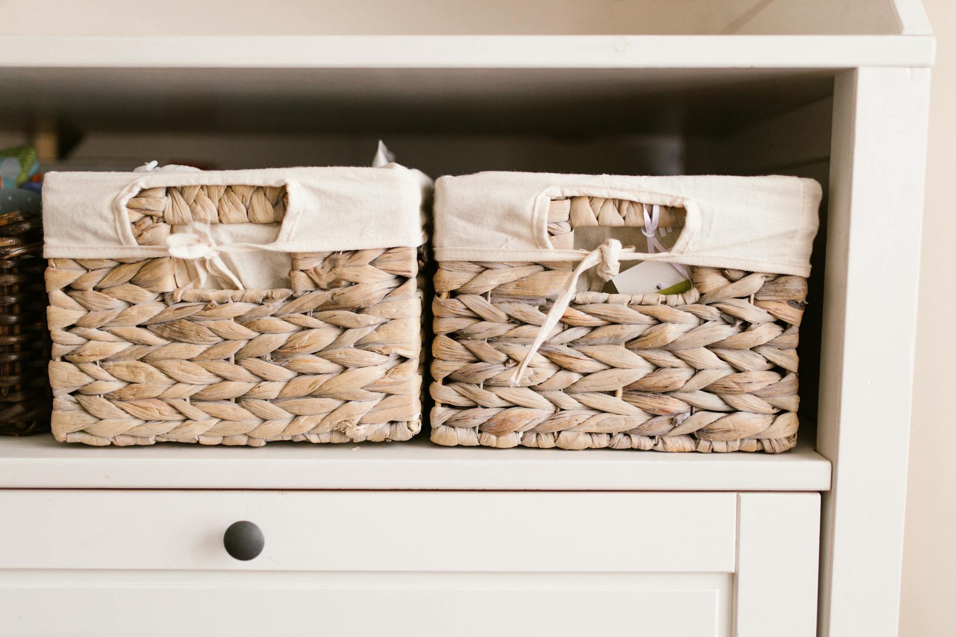 crochet basket patterns guide - Stylish woven baskets neatly arranged on a white shelf for home organization solutions.