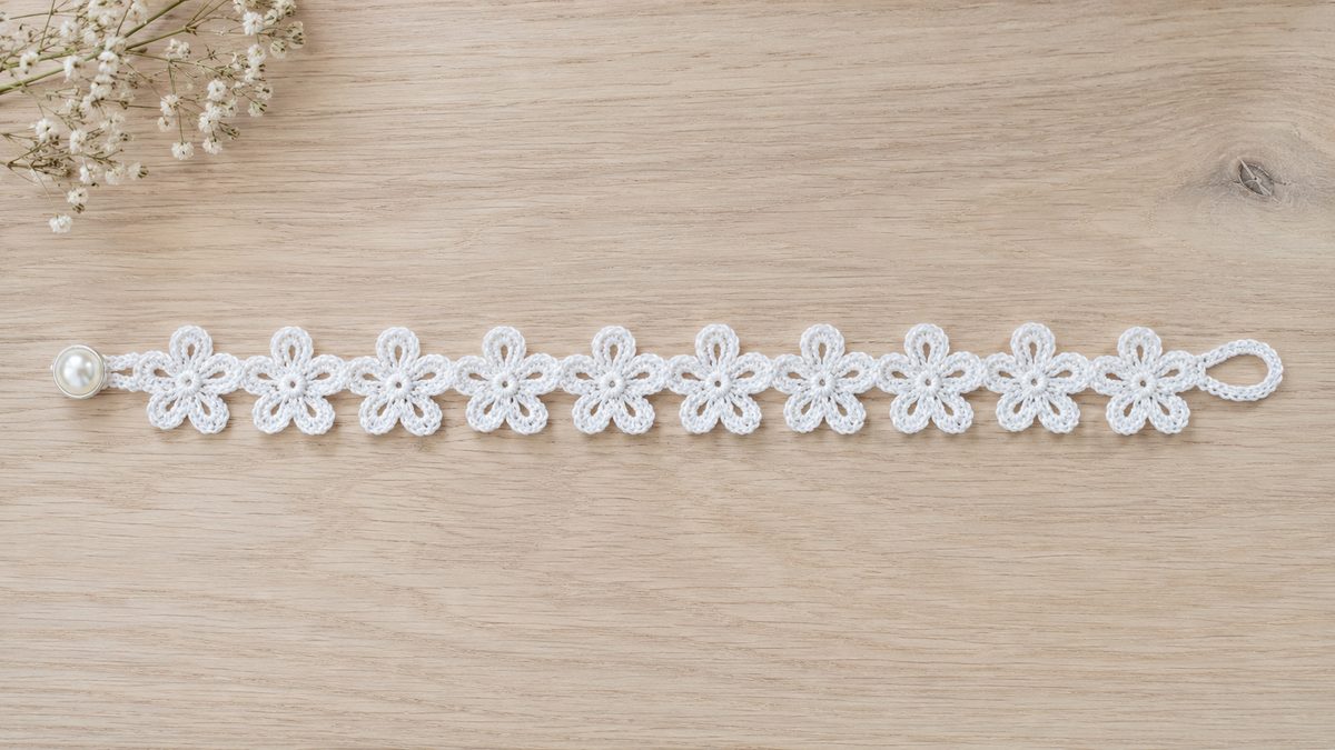 Full crochet flower bracelet laid flat showing all five-petal daisies