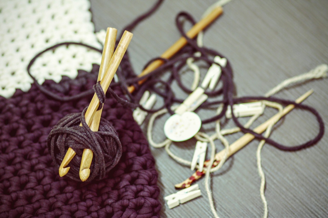 Hands crocheting with green yarn