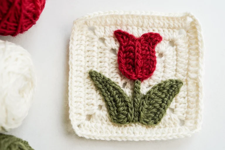 Tulip granny square with red bloom on cream background showing the complete floral motif