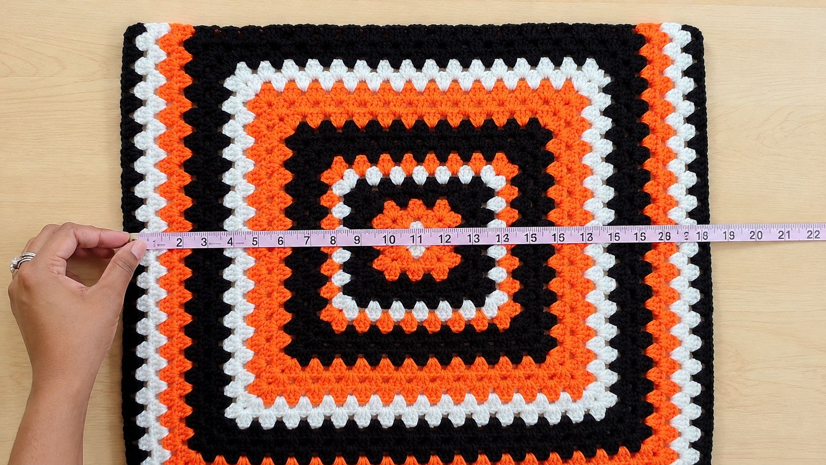 Measuring a completed granny square for shorts project