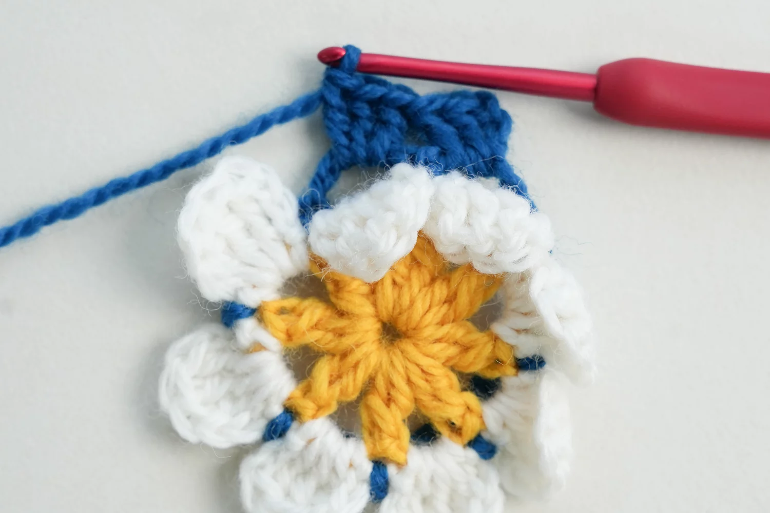 3D flower granny square rounds 5-6 showing growing blue border