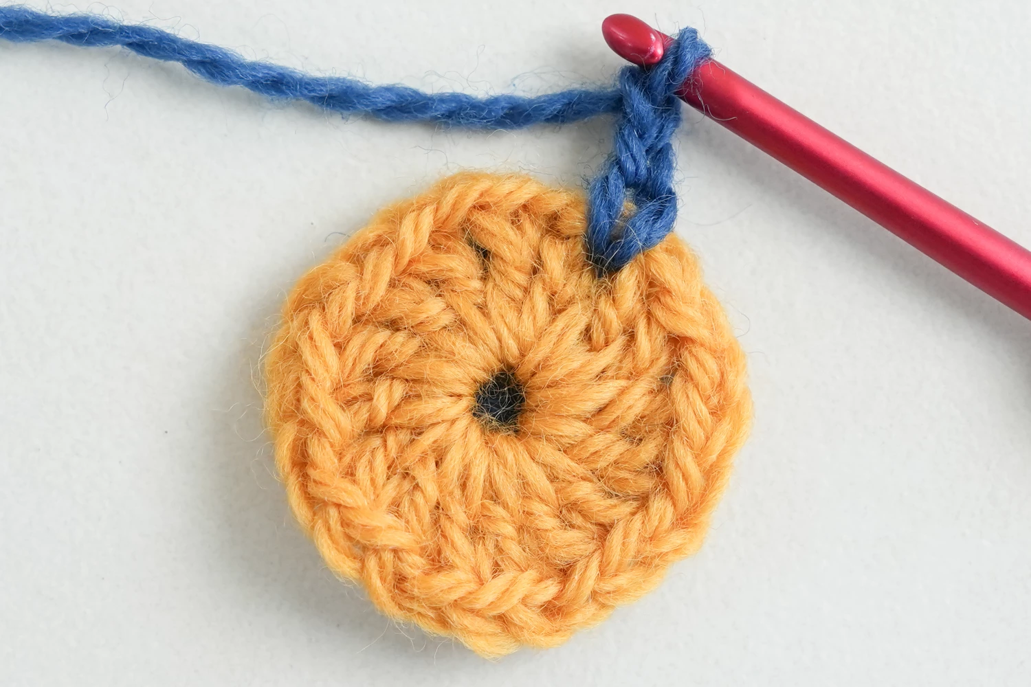 African flower granny square round 5 showing encasing stitches in yellow