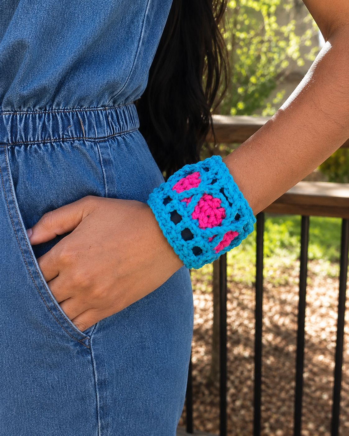 Single wide crochet bangle with blue openwork stitch pattern and pink floral accents