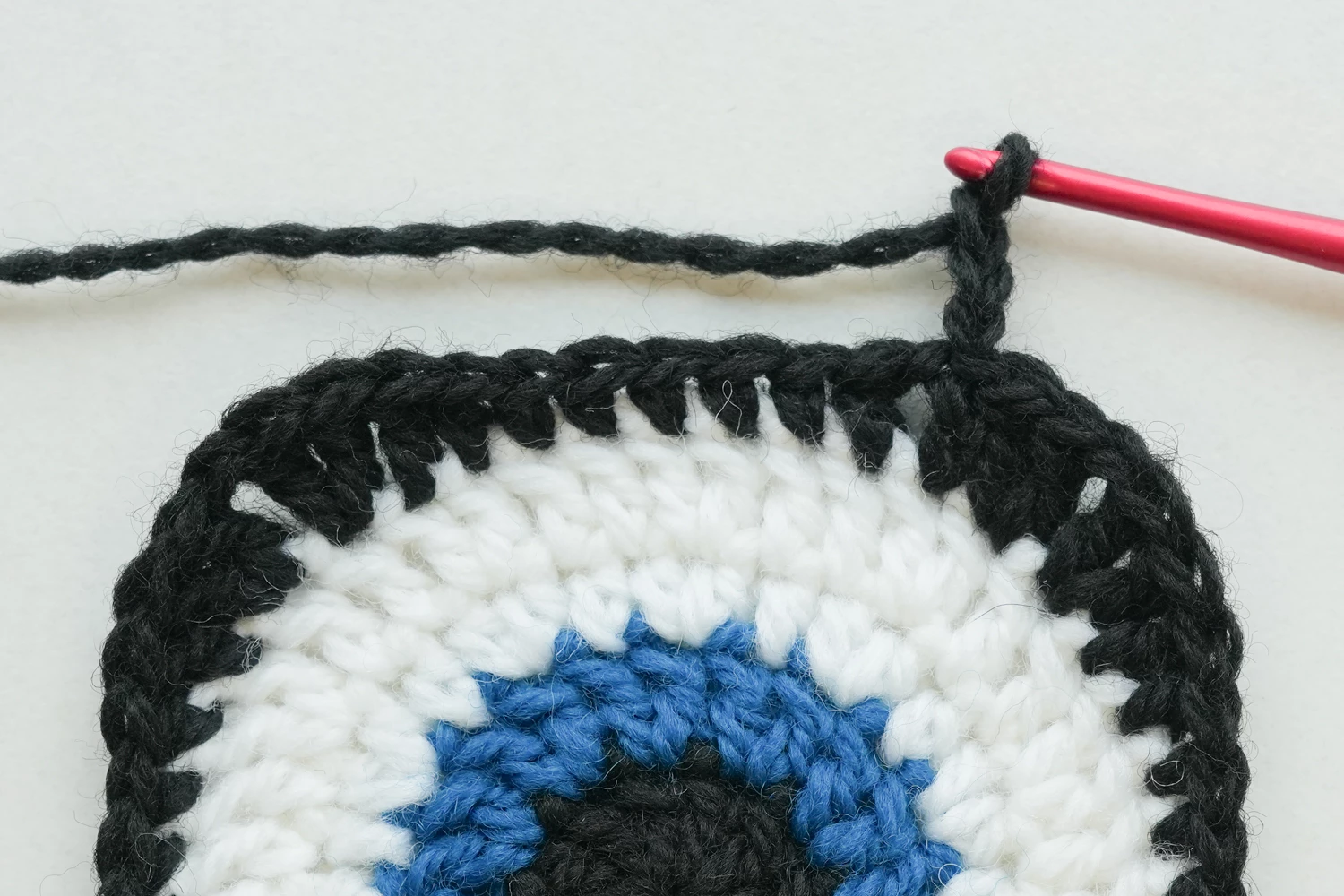Devil Eye Granny Square Round 5 complete - red layer with corners forming