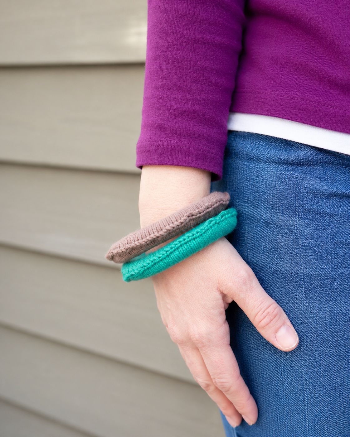 Two brown and teal simple crochet bangle bracelets worn on wrist