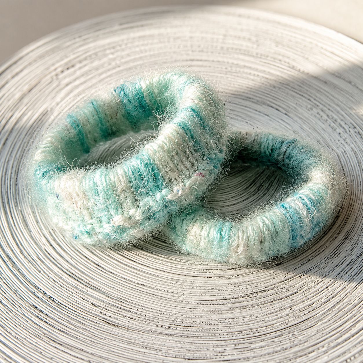 Two fuzzy light blue and white crochet bangles with soft textured stitch pattern