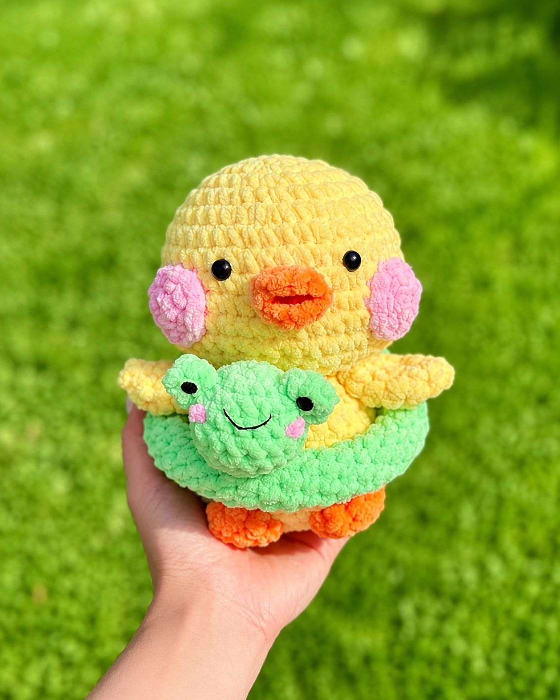 Yellow duck holding green frog floating tube wearing green swim ring amigurumi