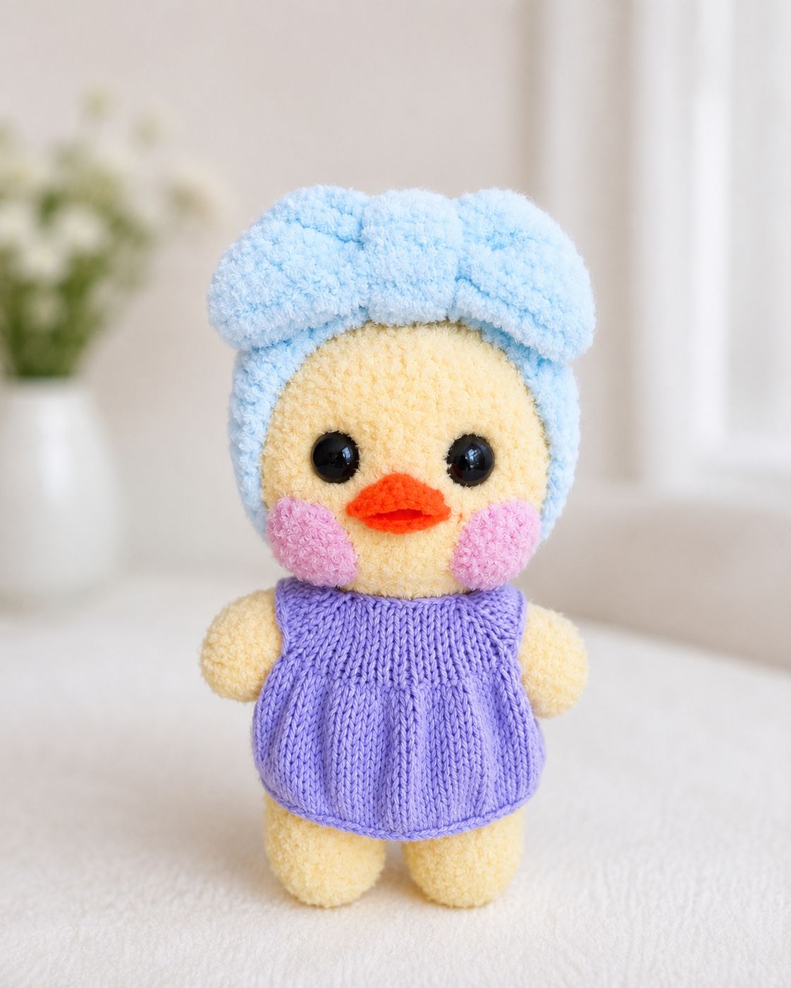 Yellow Lalafanfan duck with light blue bow headband and purple dress