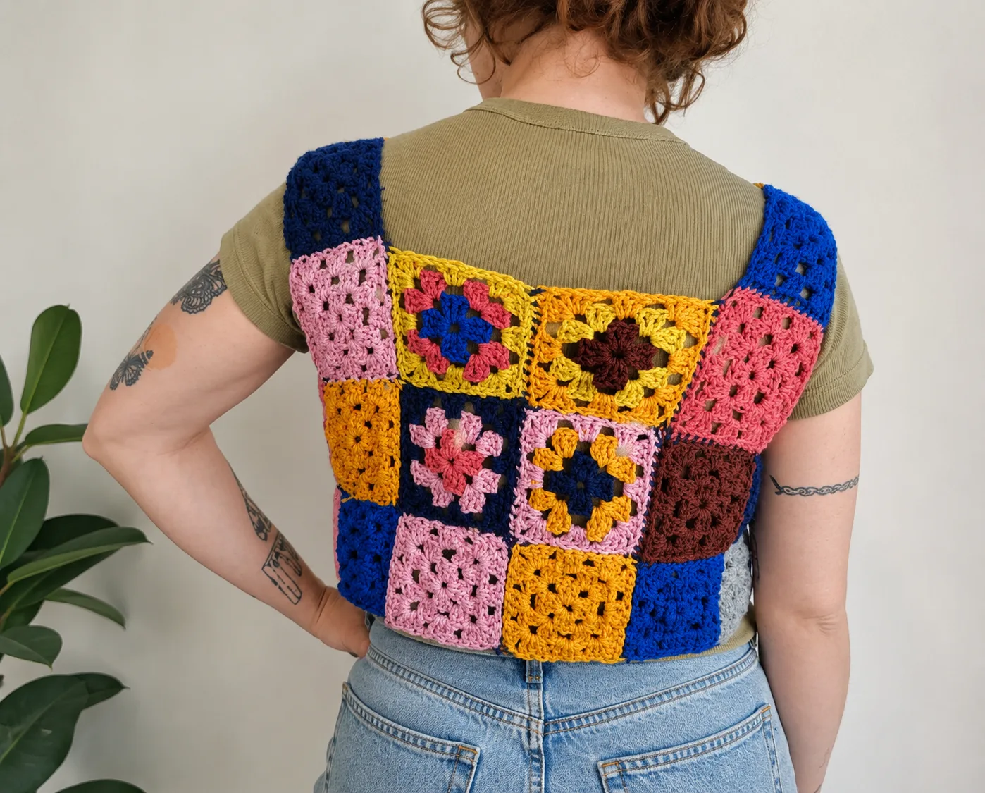 Back view of a colorful handmade crochet granny square vest
