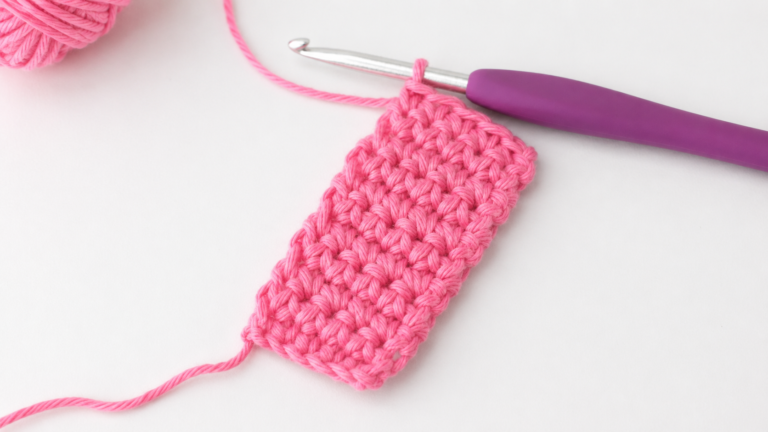 Pink crochet swatch and hook showing compact single crochet stitches