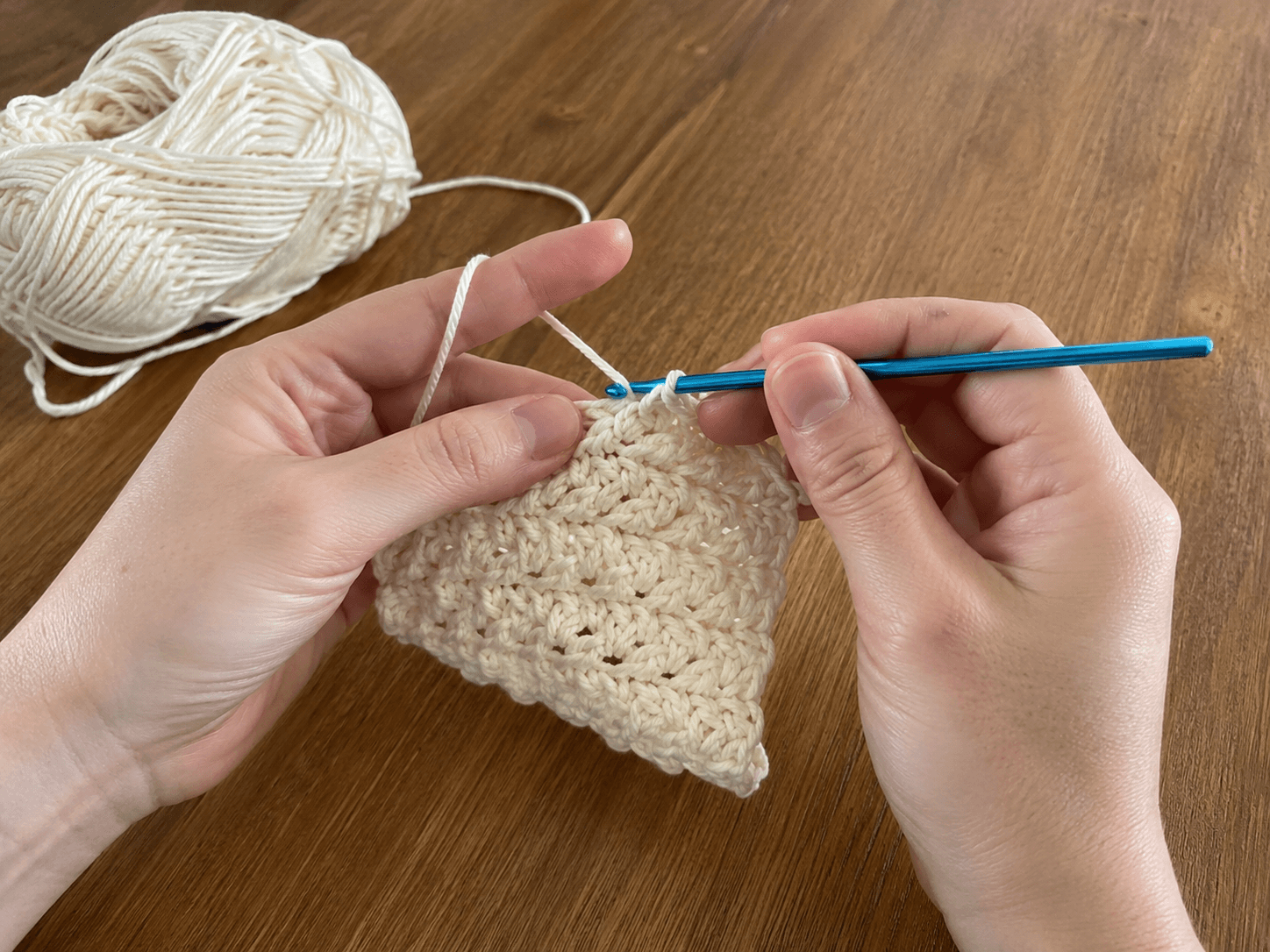 Crocheter practicing basic stitches with worsted-weight yarn