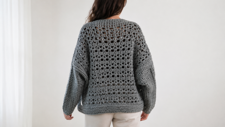 Adult wearing a gray handmade crochet bolero with a lacy back panel