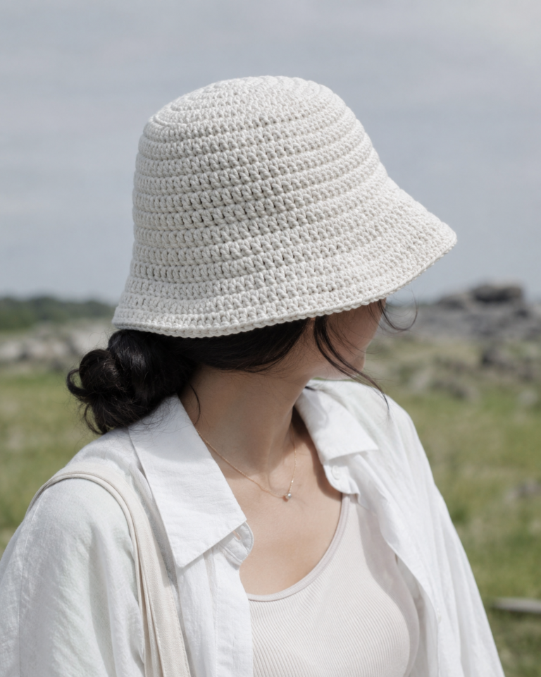 Person wearing a white double crochet bucket hat outdoors