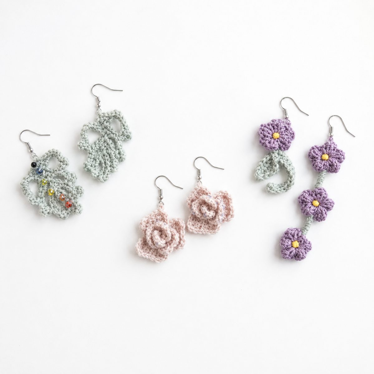 Three pairs of floral crochet earrings: beaded leaf drops, blush roses and purple flower chains