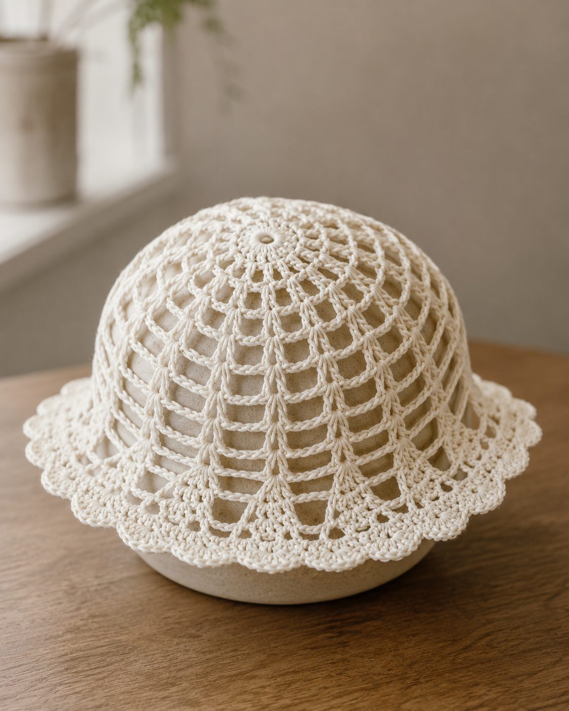 Crochet mesh hat blocked over an upturned bowl to set the dome shape