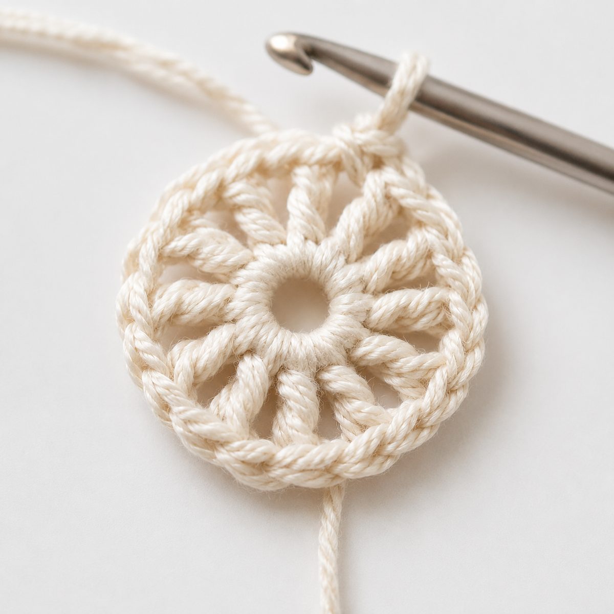 Round 1 of the crochet mesh hat, twelve double crochet spokes worked around a magic ring