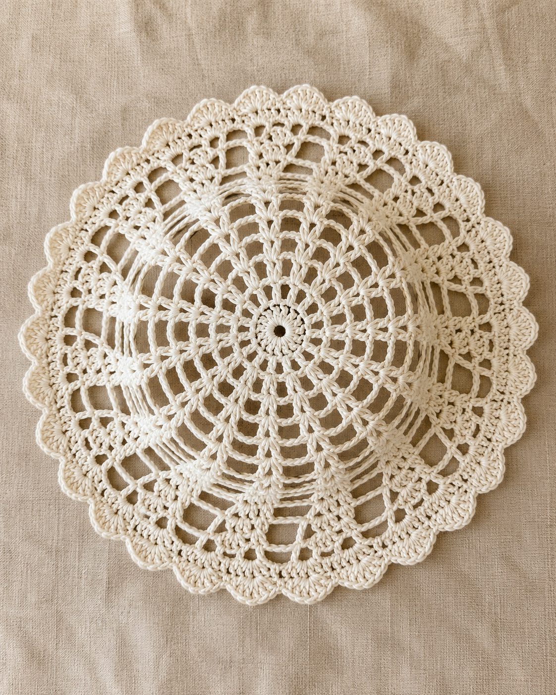 Crochet mesh hat from above, open lattice crown with twelve spokes radiating from the center