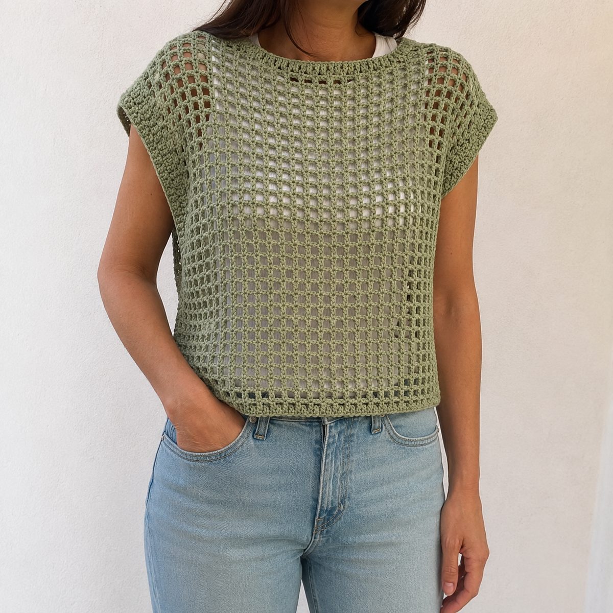 Sage green crochet mesh top worn over a white tank with light jeans, boxy fit with little cap sleeves