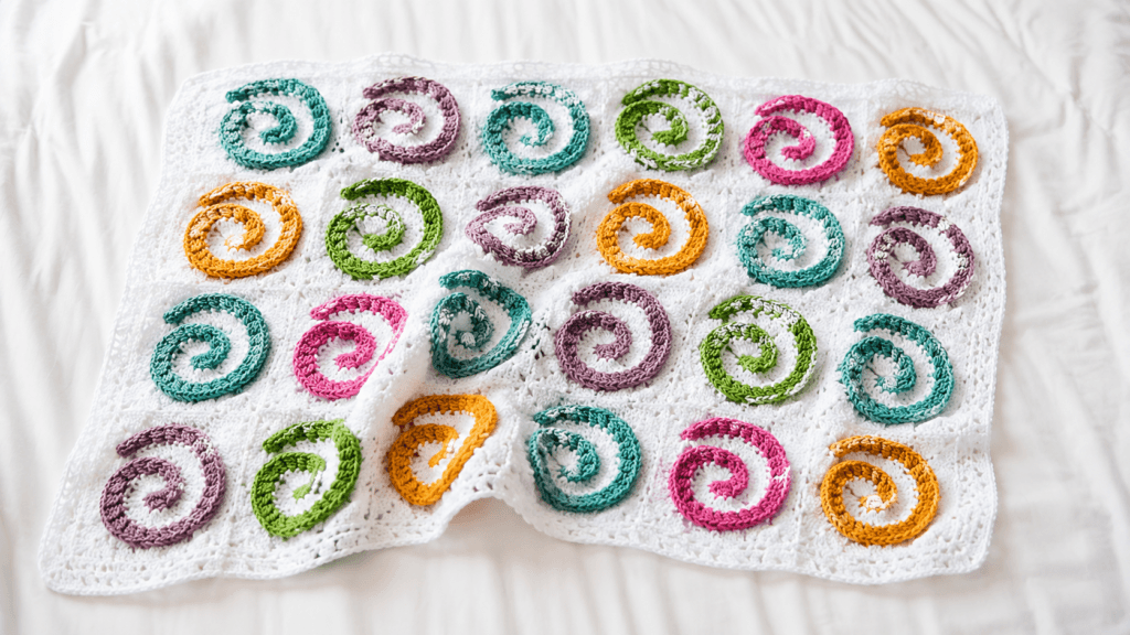 White crochet textile with raised colorful spiral motifs