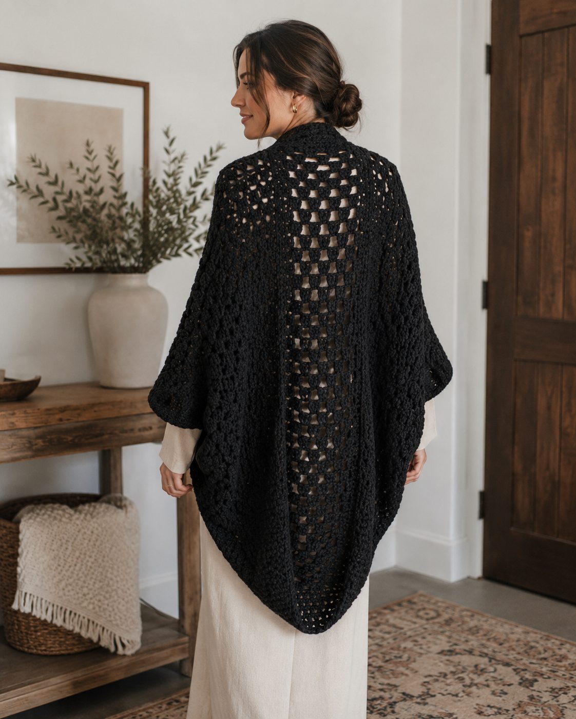 Black cocoon crochet shrug in openwork granny stitch seen from the back