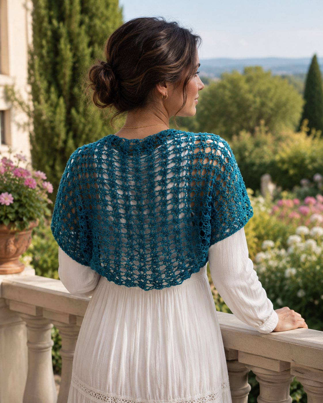 Teal lacy crochet shrug seen from the back, light openwork over a white dress