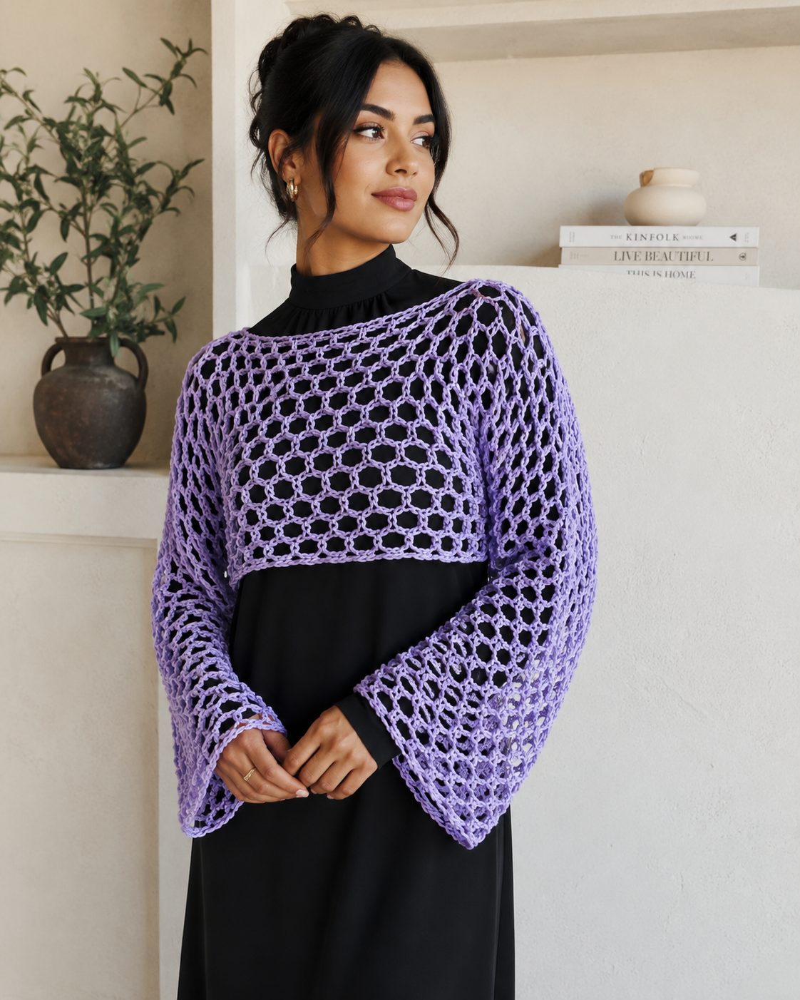 Cropped lilac open mesh crochet shrug with long bell sleeves over a black dress