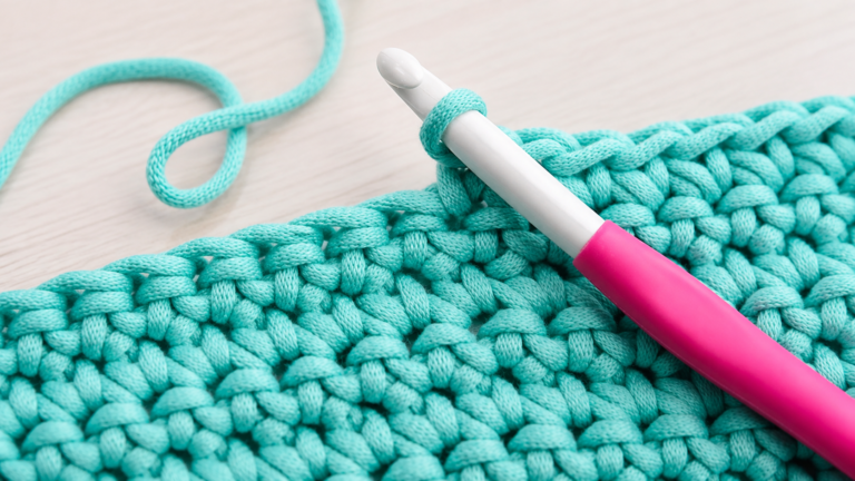 Lime green double crochet swatch with tall stitch posts and a crochet hook
