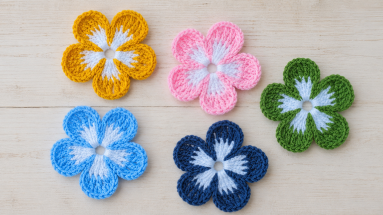Set of colorful crocheted flower motifs on a light wooden surface