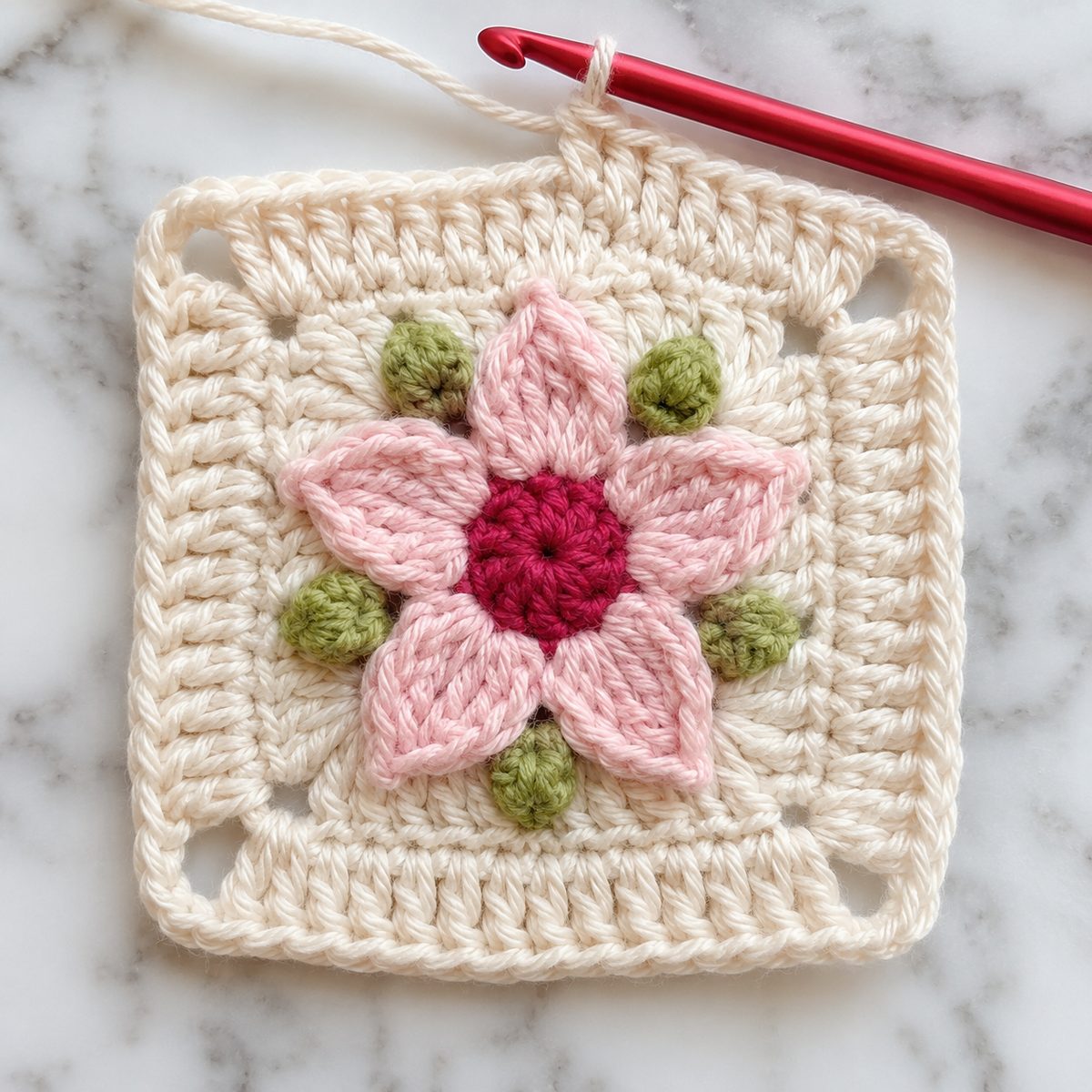 Round 6 cream double crochet border worked around the flower square, red hook at the top edge