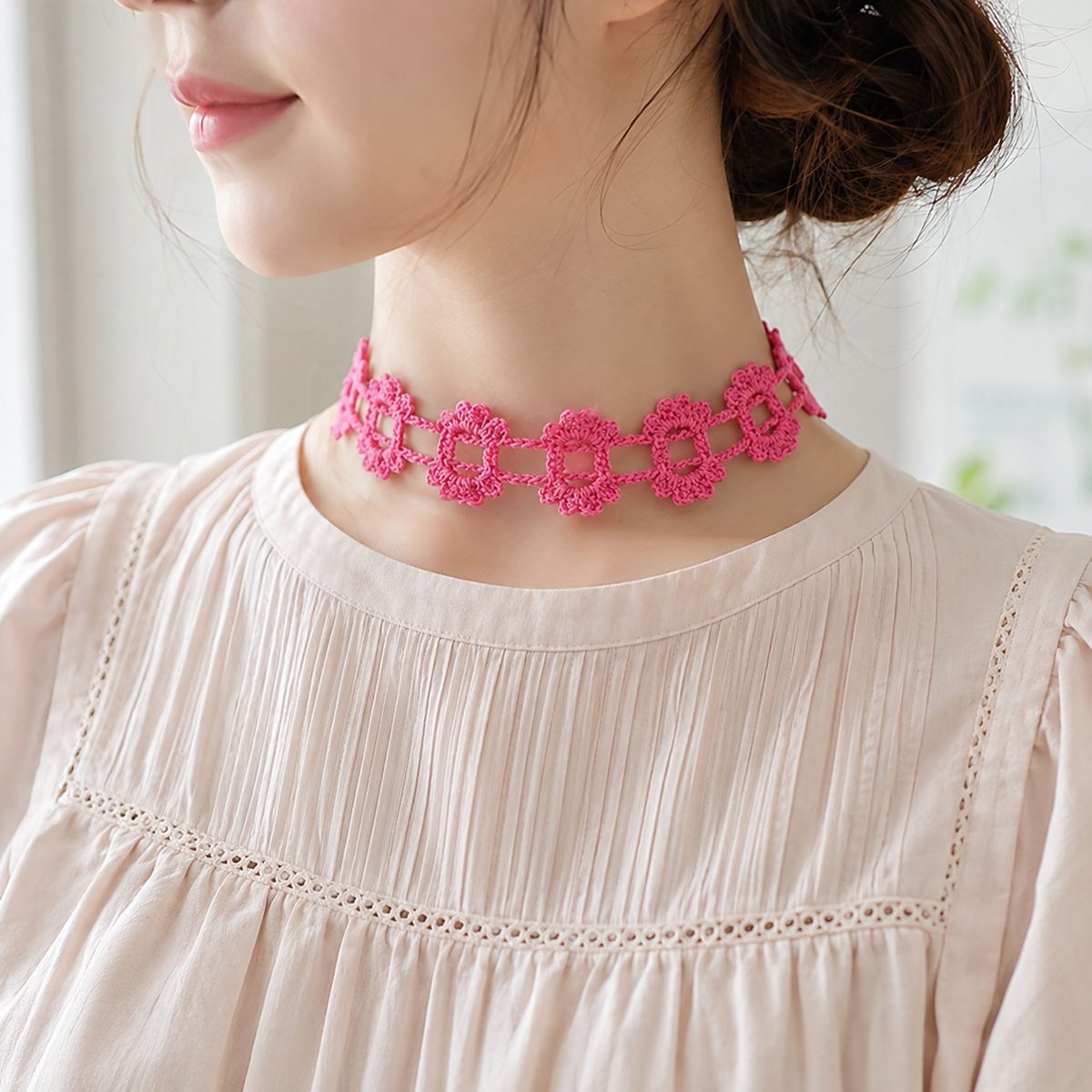Dainty pink crochet flower chain choker worn with a light blouse