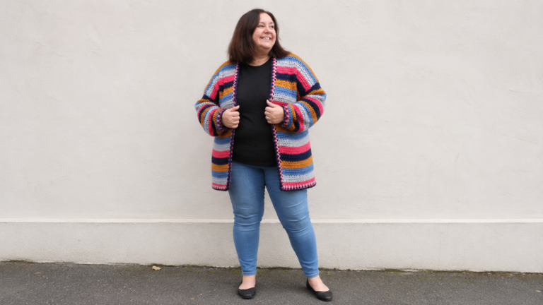 Adult wearing a multicolored striped crochet cardigan
