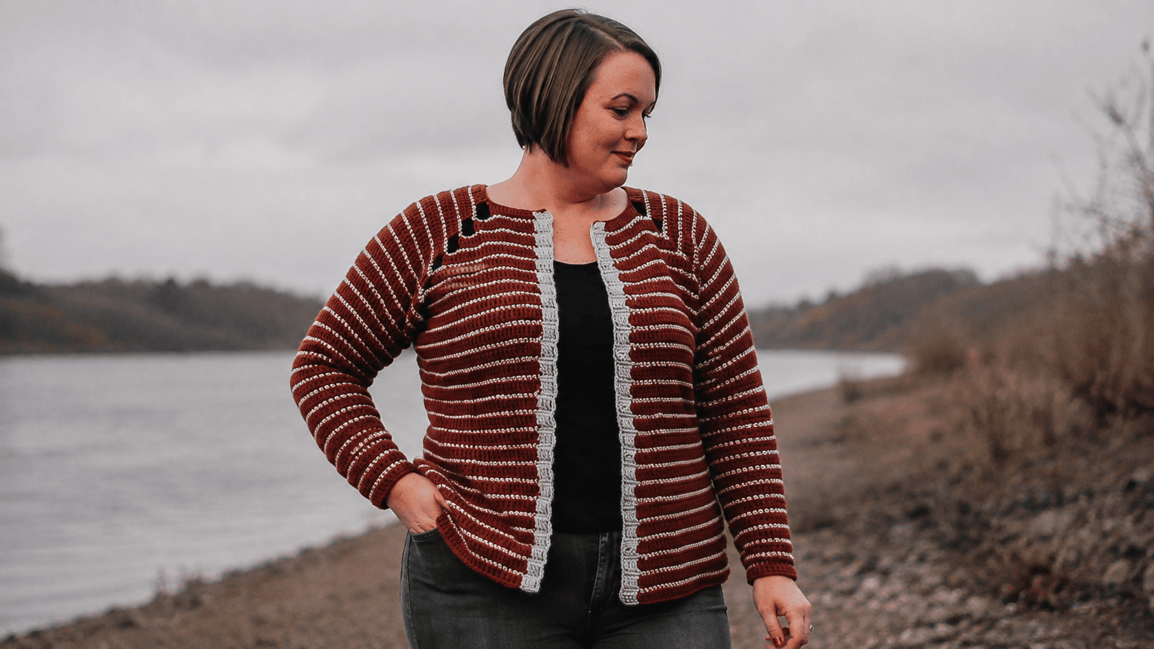 Adult wearing a rust red and white striped crochet cardigan