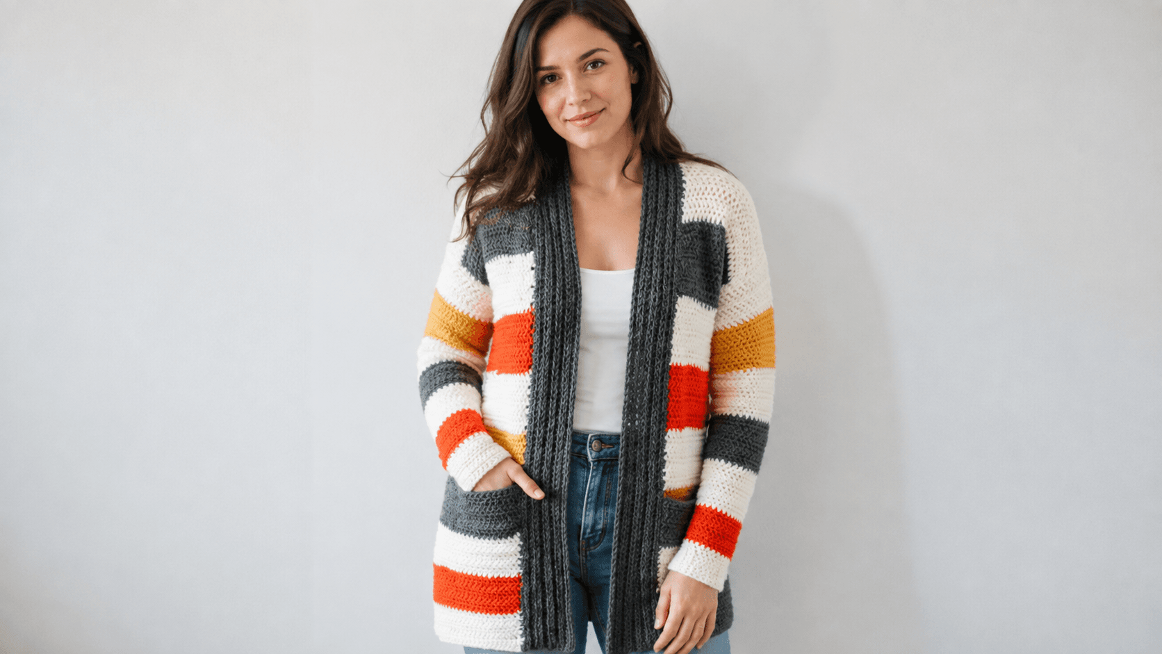 Adult wearing a long multicolored striped crochet cardigan