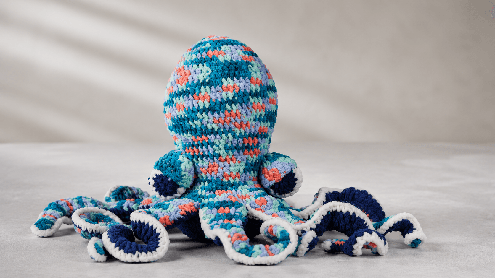 Large marled teal coral and blue crochet octopus amigurumi, studio shot