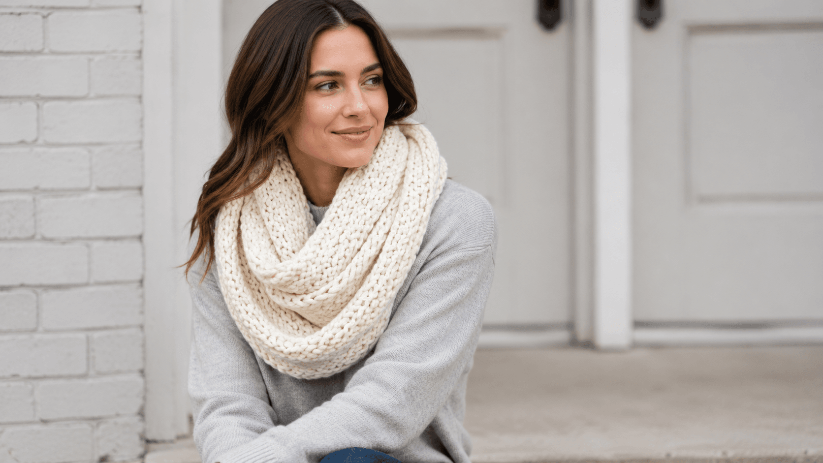 Woman wearing a cream chunky crocheted infinity scarf